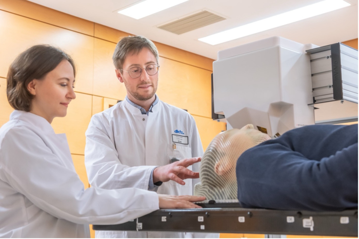 two scientists in a medical examination room with a patient